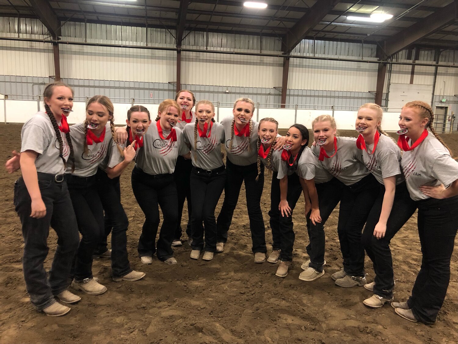 From left, drill team riders Cyndle Haller, Hailee Hellum, Madison Smith, Reagan Olson, Katie Dippo, Shaylie Flanery, Shanelle Mathus, Raylee Anderson, Jeznee Journee, Jaden Hellum and Maizy Samuelson bite down on their second place medals at the state meet in Moses Lake.